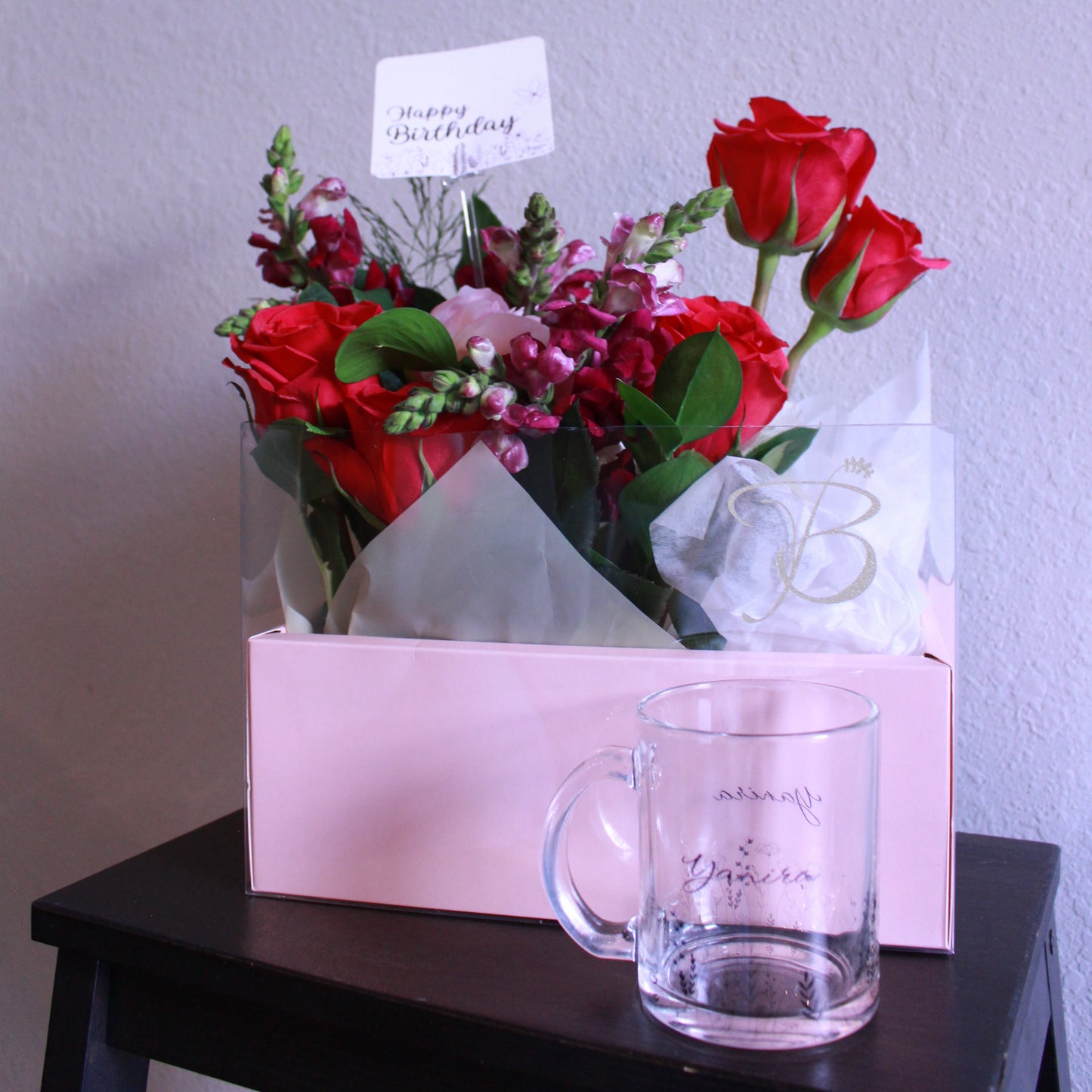Bouquet of red flowers with a glass mug on a white surface